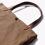 Close up of biscuit Buoy tote leather handle attachment and hardware | KlippiK Middle East