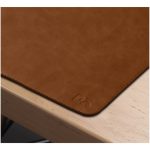 Tan vegan leather side of the Turf 2.0 mat lying on a light wood desk