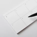Roda Week Pad open on a desk with a pen, showing the seven-day grid layout
