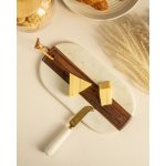 Oval cheese board in wood and white marble with its brass-handled knife, styled on a neutral table