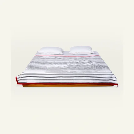 Cloudy Black with Candy Red Muted Layers Dohar shown made up on a low wooden platform bed with two matching pillows