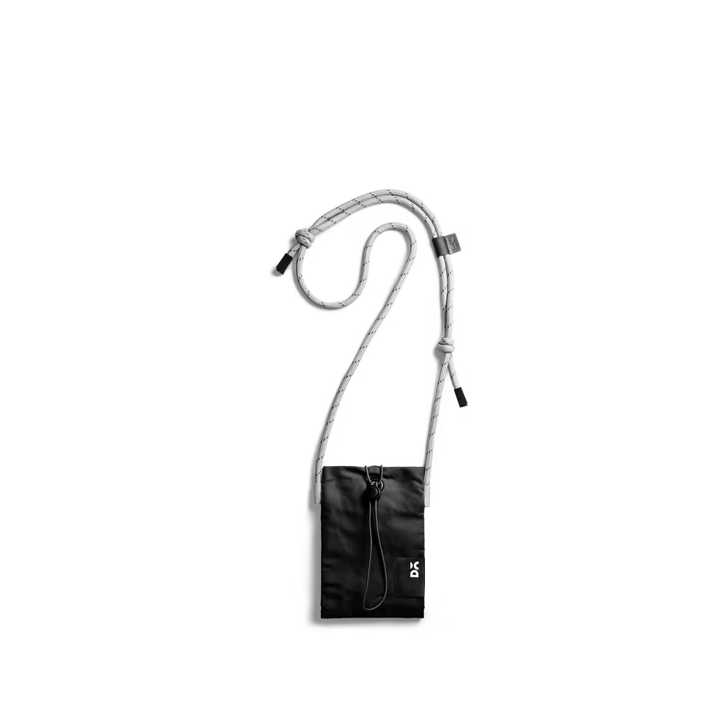 Carbon-Black-Kick-Phone-Pocket Carbon Black Kick Phone Pocket with its crossbody cord, shown hanging on white