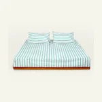 Pearl Green with Candy Red Muted Layers Flat Bedsheet shown made up on a low wooden platform bed with two matching pillows