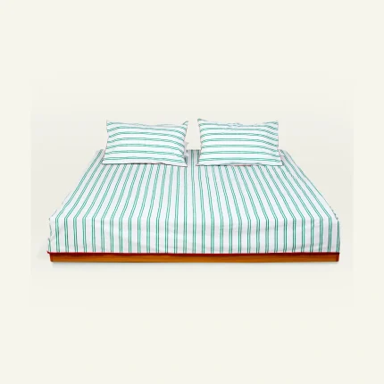 Pearl Green with Candy Red Muted Layers Flat Bedsheet shown made up on a low wooden platform bed with two matching pillows