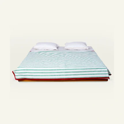 Pearl Green with Candy Red Muted Layers Dohar shown made up on a low wooden platform bed with two matching pillows