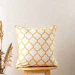 Moroccan Trellis 100% Cotton Geometric Cushion Cover For Sofa - Mustard by Yellow Dwelling, styled on a light wood stool against a pale wall