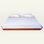 Dreamy Blue with Candy Red Muted Layers Dohar shown made up on a low wooden platform bed with two matching pillows