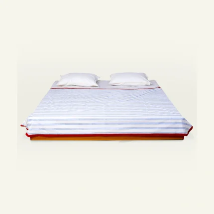 Dreamy Blue with Candy Red Muted Layers Dohar shown made up on a low wooden platform bed with two matching pillows