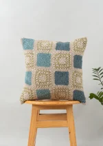 Prism Crochet Geometric Fusion Cushion Cover 100% Cotton - Blue by Yellow Dwelling, styled on a light wood stool against a pale wall