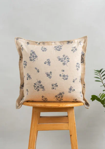 Whisper Printed Linen Flower Motif Cushion Cover for Sofa - Blue by Yellow Dwelling, styled on a light wood stool against a pale wall