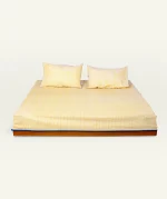 Mellow Yellow with Misty Blue Pure Stripes Flat Bedsheet shown made up on a low wooden platform bed with two matching pillows