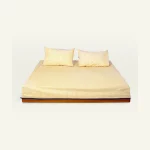 Mellow Yellow with Misty Blue Pure Stripes Flat Bedsheet shown made up on a low wooden platform bed with two matching pillows