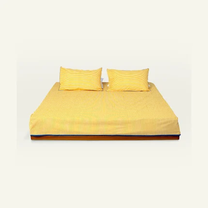 Mellow Yellow with Misty Blue Silent Stripes Flat Bedsheet shown made up on a low wooden platform bed with two matching pillows