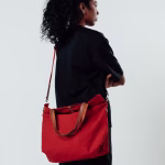 Model carrying crimson red canvas Buoy tote bag on shoulder | KlippiK Worldwide