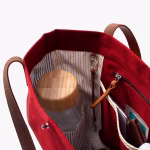 Interior view of crimson red Buoy tote with striped lining and items | KlippiK Worldwide