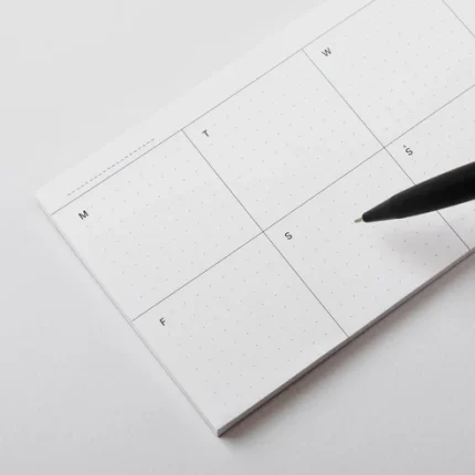 Roda Week Pad open on a desk with a pen, showing the seven-day grid layout
