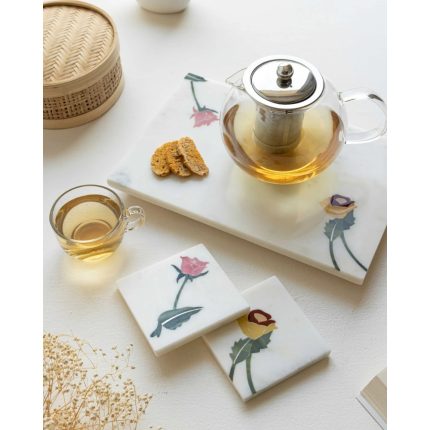 White marble tray and two coasters with coloured flower inlay, styled with a glass teapot and tea
