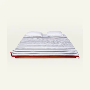 Cloudy Black with Candy Red Muted Layers Dohar shown made up on a low wooden platform bed with two matching pillows