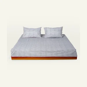 Cloudy Black with Candy Red Pure Stripes Flat Bedsheet shown made up on a low wooden platform bed with two matching pillows