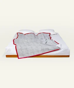 Cloudy Black with Candy Red Pure Stripes Flat Bedsheet shown made up on a low wooden platform bed with two matching pillows