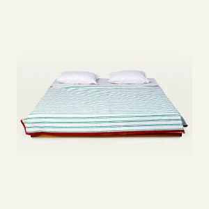Pearl Green with Candy Red Muted Layers Dohar shown made up on a low wooden platform bed with two matching pillows