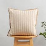 Loom Linen Minimal Design Cushion Cover for Sofa - Beige by Yellow Dwelling, styled on a light wood stool against a pale wall