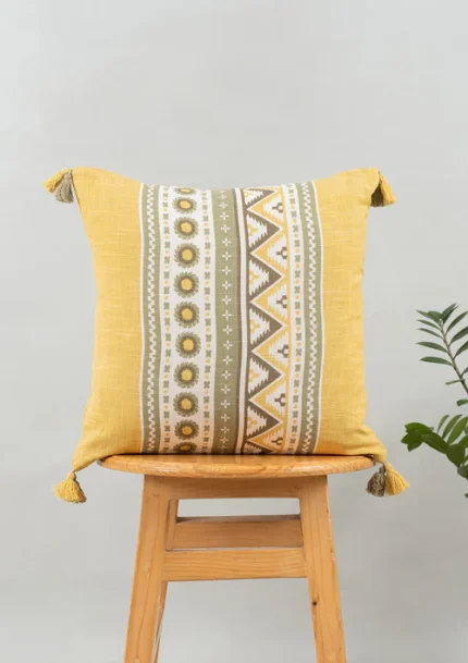 Nadar 100% Cotton Printed Geometric Cushion Cover for Sofa with Tassels – Yellow by Yellow Dwelling, styled on a light wood stool against a pale wall