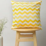 Ombre Chevron Cotton Cushion Cover - Yellow by Yellow Dwelling, styled on a light wood stool against a pale wall