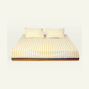 Mellow Yellow with Misty Blue Muted Layers Flat Bedsheet shown made up on a low wooden platform bed with two matching pillows
