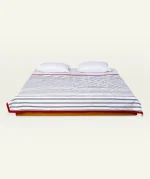 Cloudy Black with Candy Red Muted Layers Dohar shown made up on a low wooden platform bed with two matching pillows