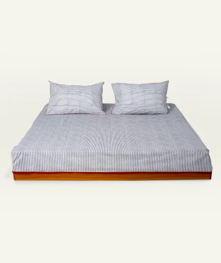 Cloudy Black with Candy Red Pure Stripes Flat Bedsheet shown made up on a low wooden platform bed with two matching pillows