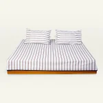 Mocha Brown with Haze Indigo Muted Layers Flat Bedsheet shown made up on a low wooden platform bed with two matching pillows