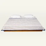 Mocha Brown with Haze Indigo Muted Layers Dohar shown made up on a low wooden platform bed with two matching pillows
