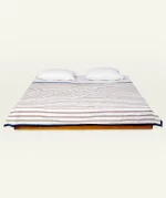 Mocha Brown with Haze Indigo Muted Layers Dohar shown made up on a low wooden platform bed with two matching pillows