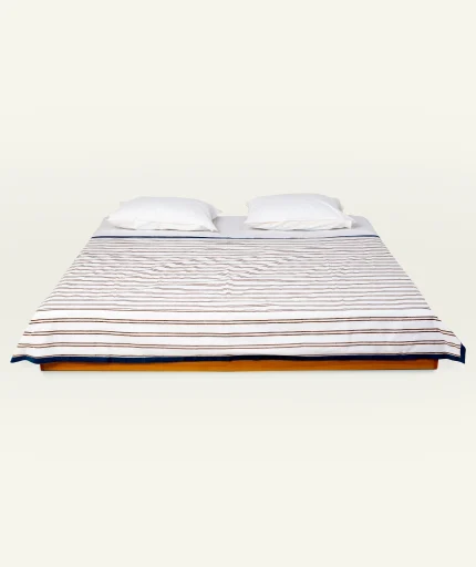 Mocha Brown with Haze Indigo Muted Layers Dohar shown made up on a low wooden platform bed with two matching pillows
