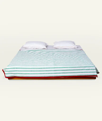 Pearl Green with Candy Red Muted Layers Dohar shown made up on a low wooden platform bed with two matching pillows