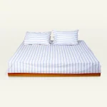 Dreamy Blue with Candy Red Muted Layers Flat Bedsheet shown made up on a low wooden platform bed with two matching pillows