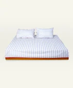 Dreamy Blue with Candy Red Muted Layers Flat Bedsheet shown made up on a low wooden platform bed with two matching pillows