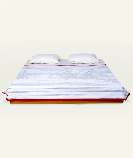 Dreamy Blue with Candy Red Muted Layers Dohar shown made up on a low wooden platform bed with two matching pillows