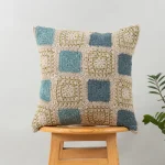 Prism Crochet Geometric Fusion Cushion Cover 100% Cotton - Blue by Yellow Dwelling, styled on a light wood stool against a pale wall