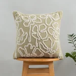 Stella Embroidered Flower Pattern 100% Cotton Cushion Cover for Sofa - Herb Green by Yellow Dwelling, styled on a light wood stool against a pale wall