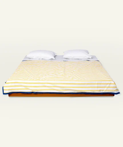 Mellow Yellow with Misty Blue Muted Layers Dohar shown made up on a low wooden platform bed with two matching pillows
