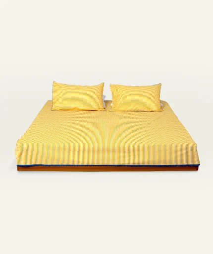 Mellow Yellow with Misty Blue Silent Stripes Flat Bedsheet shown made up on a low wooden platform bed with two matching pillows