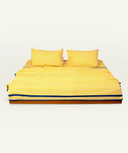 Mellow Yellow with Misty Blue Silent Stripes Dohar shown made up on a low wooden platform bed with two matching pillows