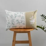 Celeste embroidered 100% Cotton Cushion Cover for Sofa - Nile Blue by Yellow Dwelling, styled on a light wood stool against a pale wall