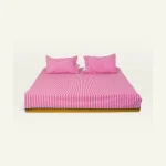 Berry Pink with Pearl Green Silent Stripes Flat Bedsheet shown made up on a low wooden platform bed with two matching pillows