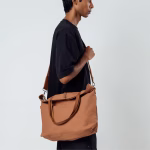 Male model wearing biscuit canvas Buoy tote crossbody over black t-shirt | KlippiK Kuwait