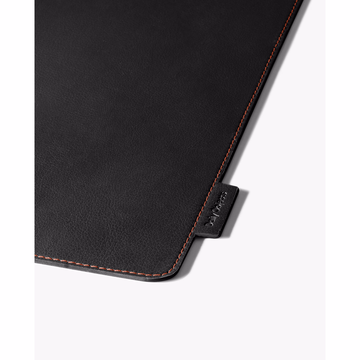 Red-Black Snap On Organiser Desk Mat with Cable Holder + Phone Mount + Apple Watch Charging Stand in Black – Close-up of textured surface with orange stitching | KlippiK