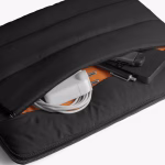 Top view of black puffy laptop sleeve holding MacBook charger inside | KlippiK Kuwait