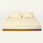 Mellow Yellow with Misty Blue Muted Layers Flat Bedsheet shown made up on a low wooden platform bed with two matching pillows